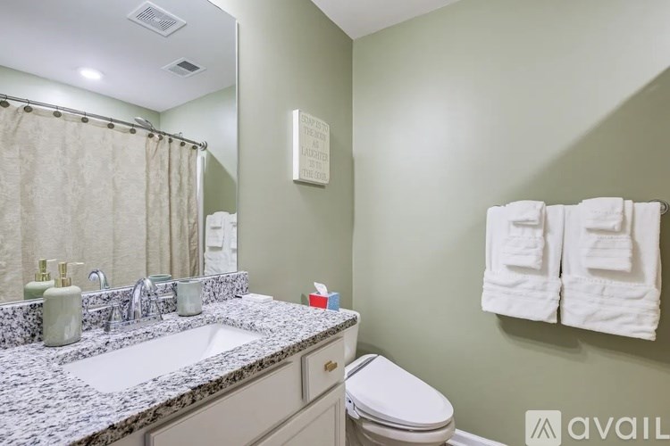 A bathroom with a toilet, sink, and towel rack.
