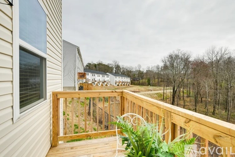 A deck with a railing and a potted plant is visible.