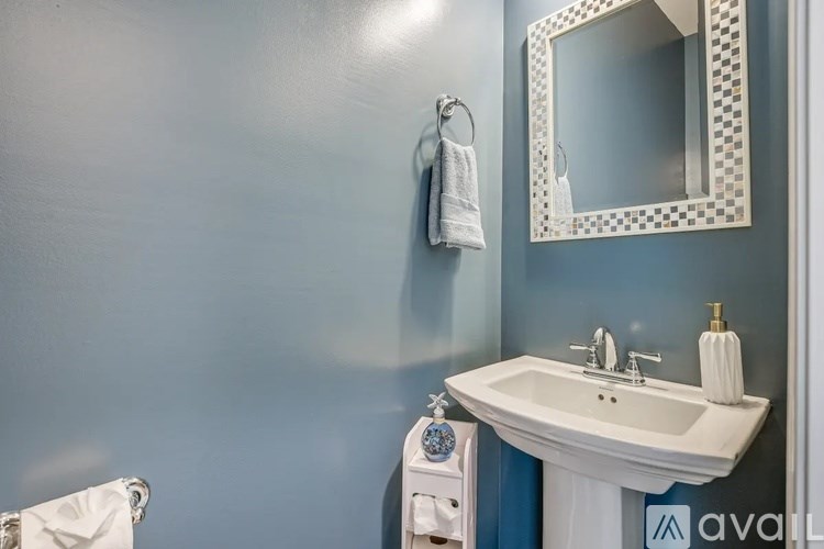 A bathroom with a white sink and a mirror above it.
