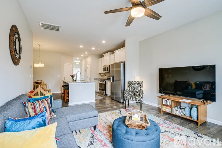 A living room with a grey couch and a blue ottoman.