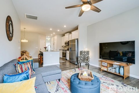 A living room with a grey couch and a blue ottoman.
