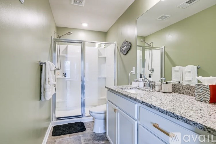 A bathroom with a toilet, sink, and shower.