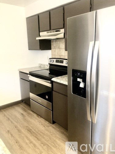 A kitchen with a stainless steel refrigerator and a stove top oven.