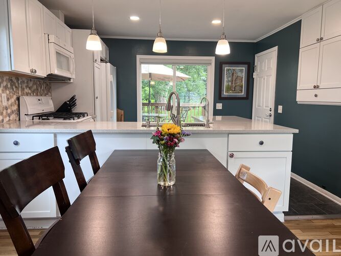 A kitchen with a brown table and white cabinets.