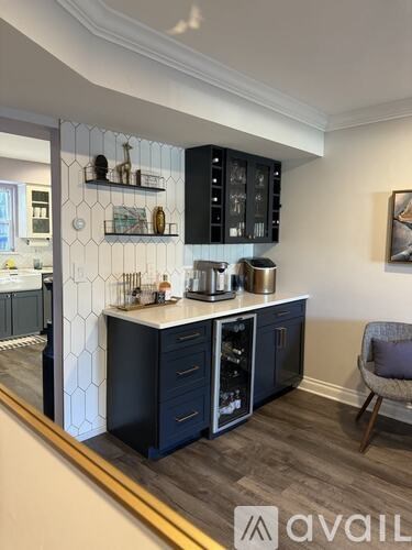 A kitchen with black cabinets and a white backsplash.