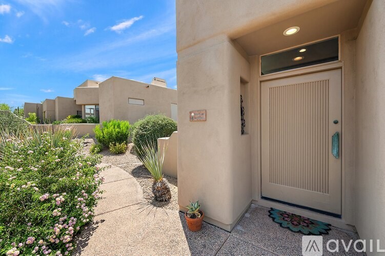 A beige door with a mat in front of it.