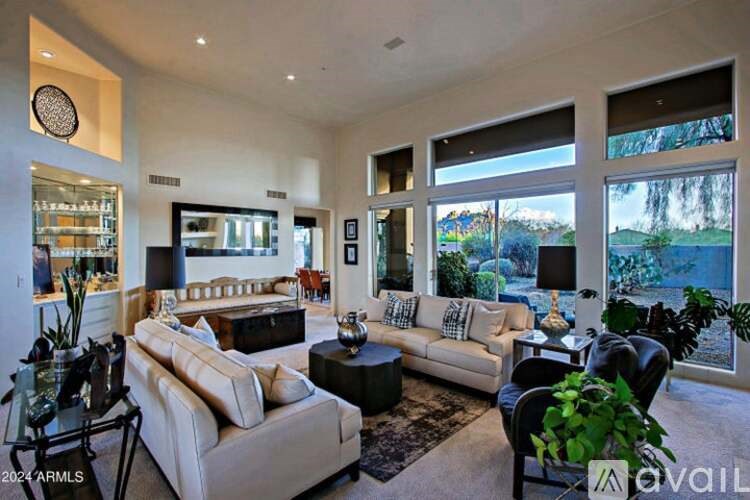 A living room with a white couch and a glass coffee table.
