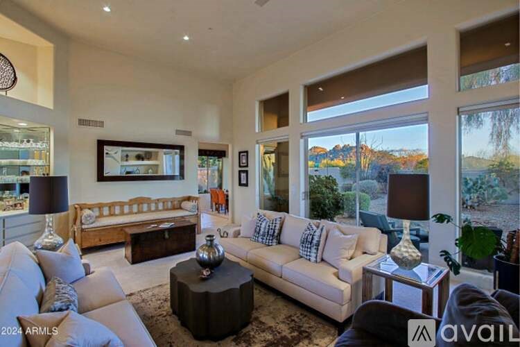 A living room with a large couch and a painting on the wall.