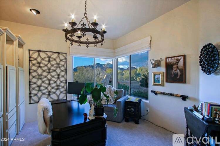A living room with a black piano and a chandelier.