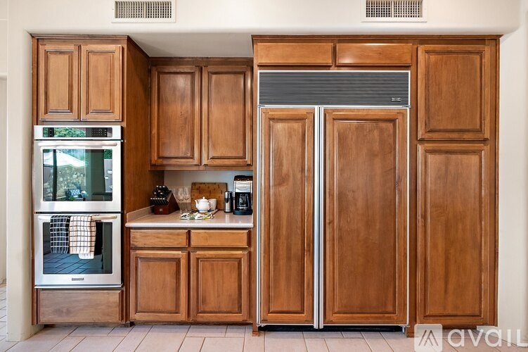 A kitchen with wooden cabinets and a refrigerator.