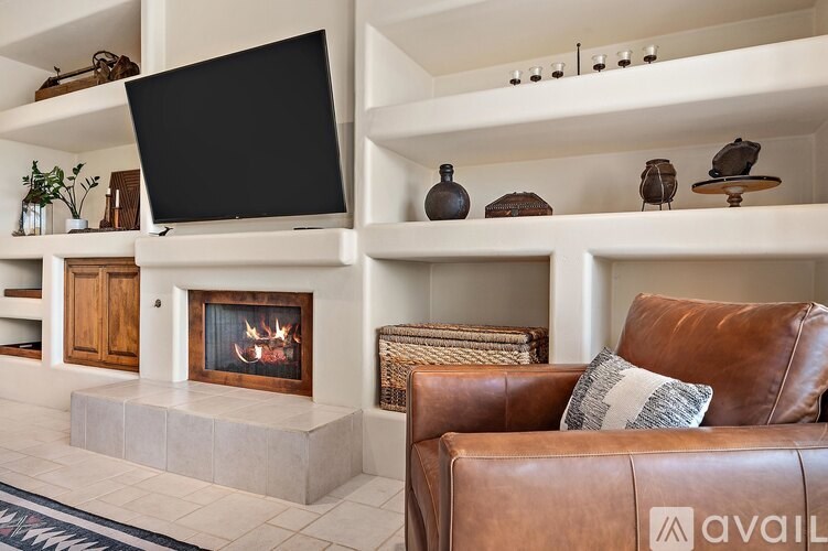 A living room with a fireplace and a leather couch.