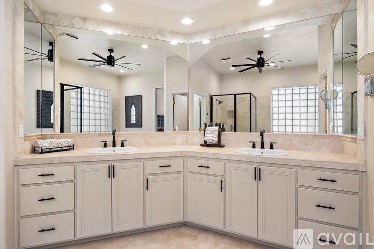 A bathroom with two sinks and a large mirror.