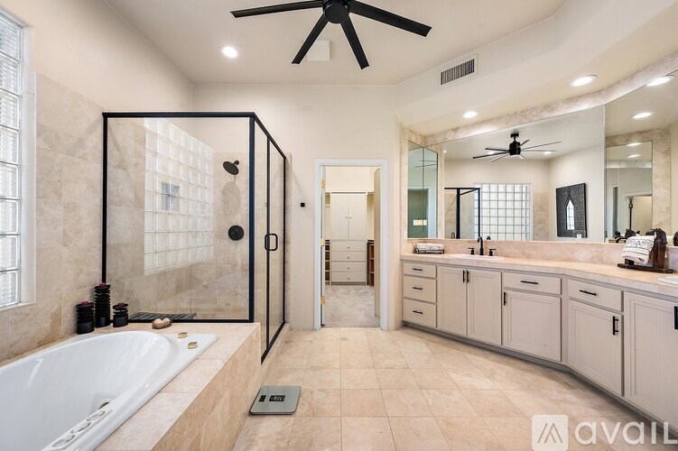 A bathroom with a white tub, a walk-in shower, and a vanity with a mirror.