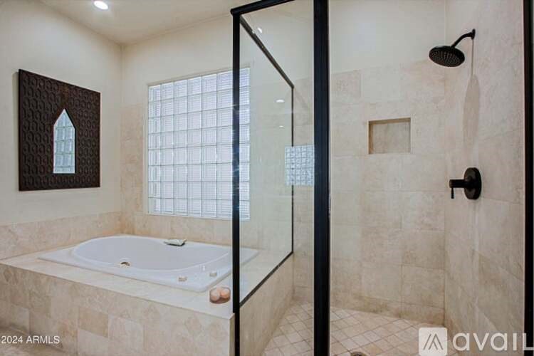 A bathroom with a glass shower door and a bathtub.