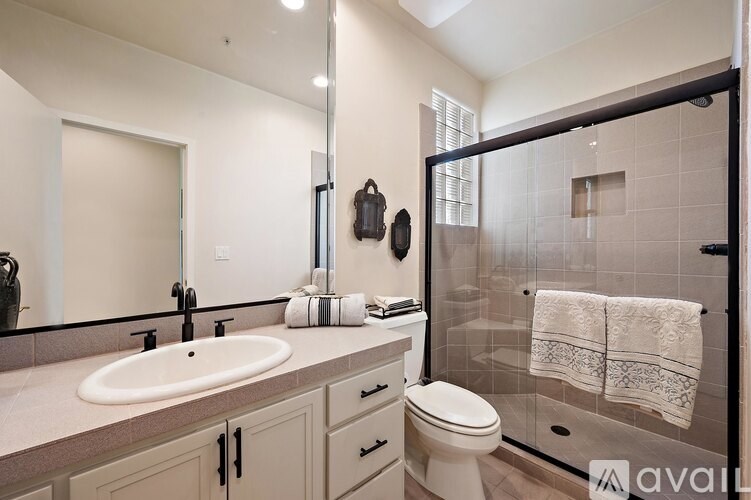 A bathroom with a sink, toilet, and shower.