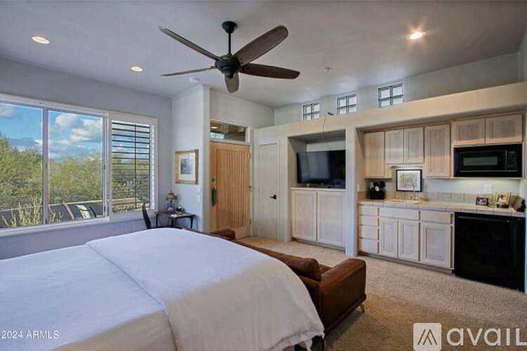 A bedroom with a large bed and a ceiling fan.