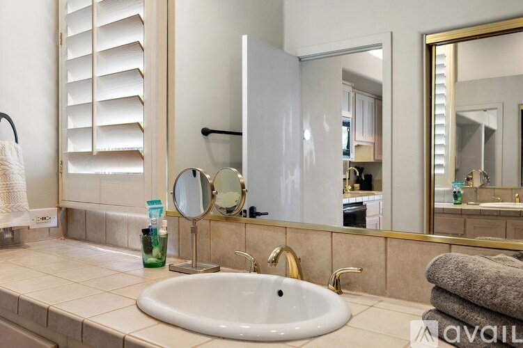 A bathroom with a white sink and a mirror.