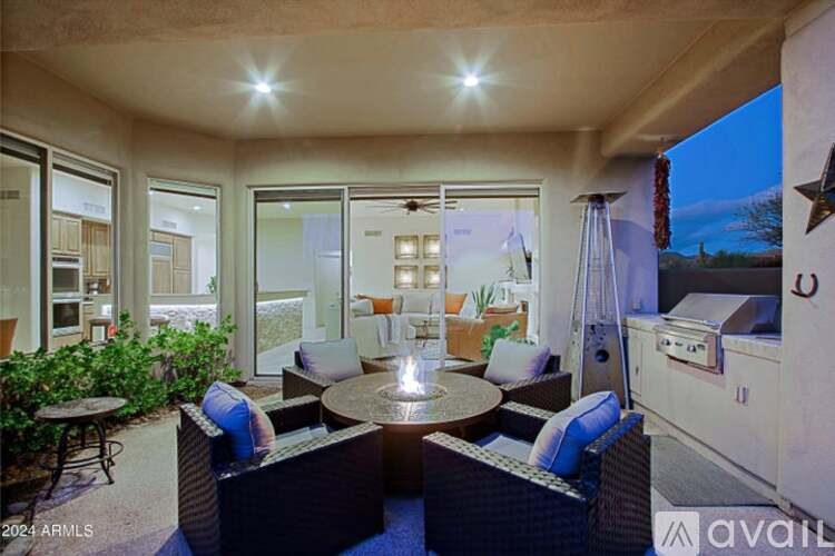 A patio with a table and chairs is set up outside a house.