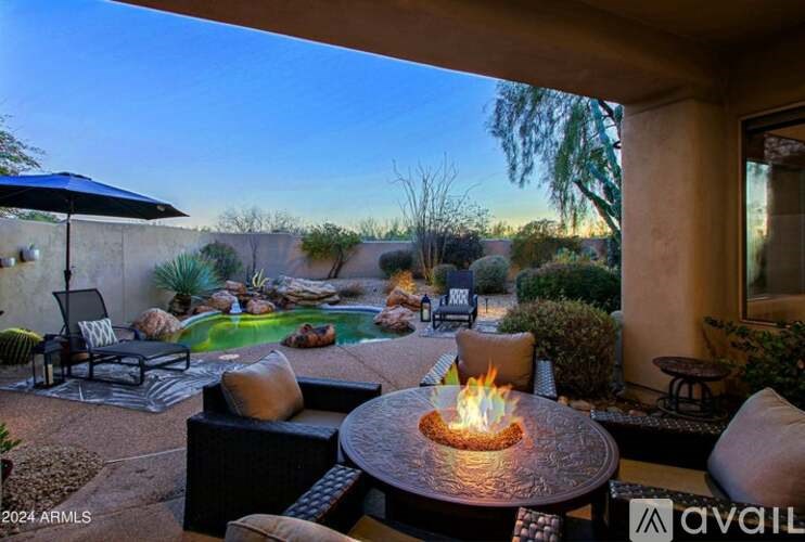 A patio with a fire pit and seating area.