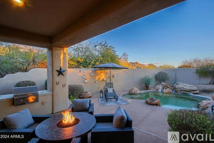 A patio with a fire pit and a hot tub.
