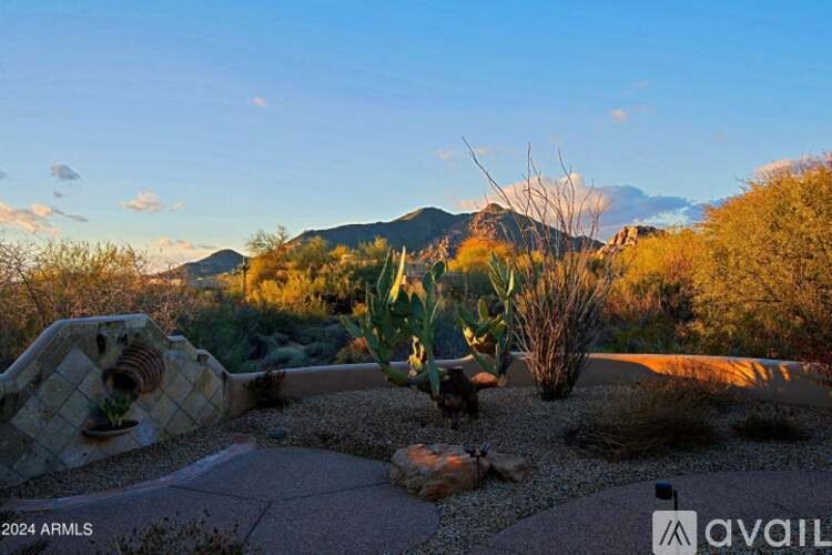 A desert landscape with a mountain in the background and a cactus in the foreground.