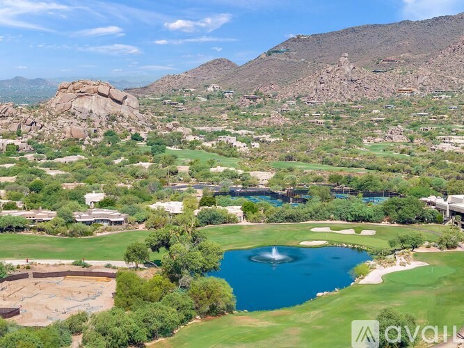 A golf course with a pond and a mountain in the background.