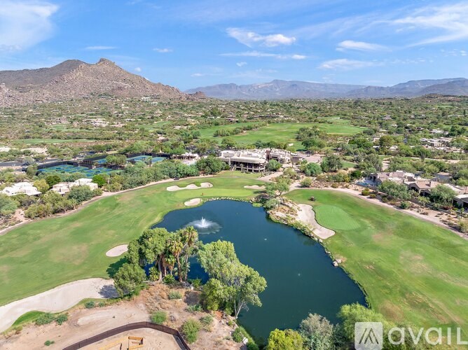 A golf course with a lake and mountains in the background.