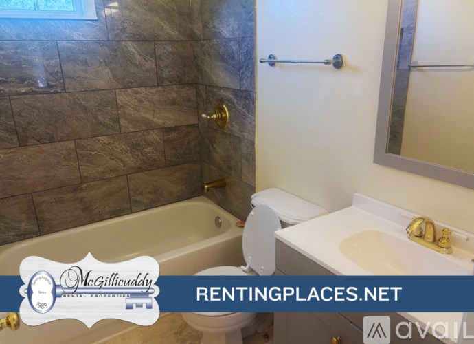 A bathroom with a tub, toilet and sink.