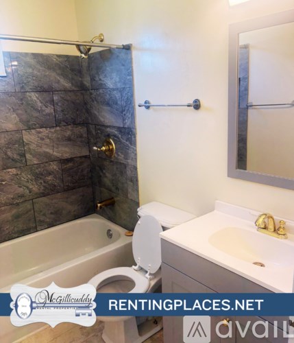 A bathroom with a toilet, sink, and bathtub.