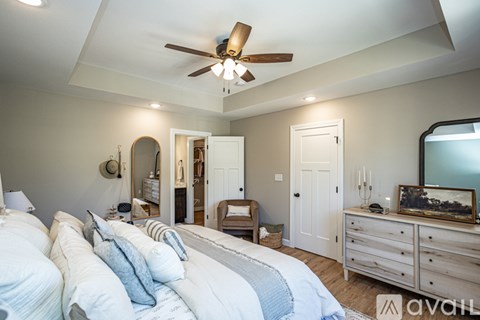 A bedroom with a large bed and a ceiling fan.