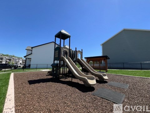 A playground with a slide and a wooden structure.