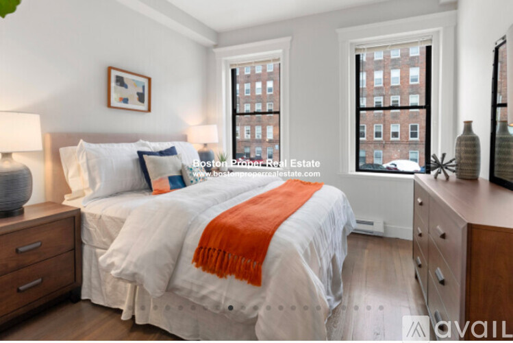 A bedroom with a large bed and a window overlooking a cityscape.