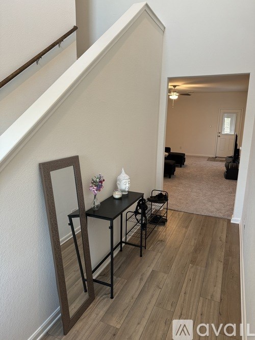A hallway with a mirror and a table with flowers on it.