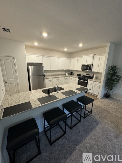 A kitchen with white cabinets and a granite countertop.