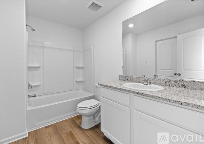 A white bathroom with a toilet, sink, and bathtub.