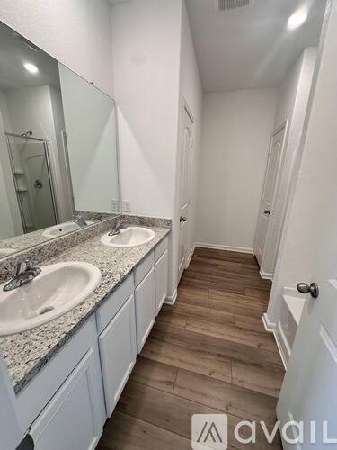 A bathroom with two sinks and a mirror.
