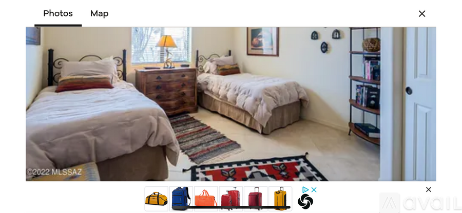 A bedroom with two beds and a dresser.