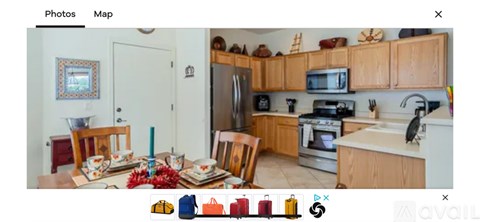 A kitchen with wooden cabinets and a stainless steel refrigerator.