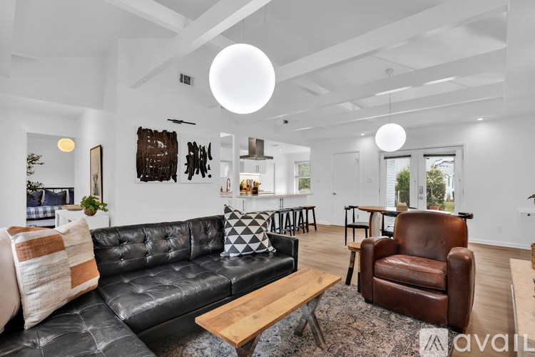 A living room with a black leather couch and a wooden coffee table.