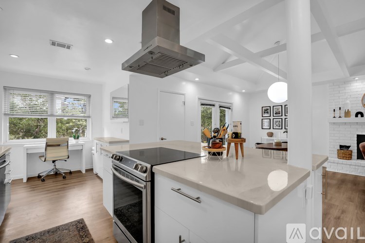 A modern kitchen with a large island and stainless steel appliances.