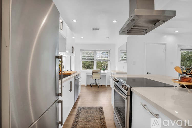A modern kitchen with stainless steel appliances and a large island.