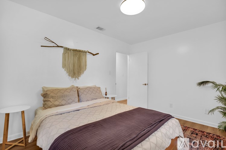 A bedroom with a bed, a chair, and a rug.