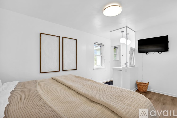 A bedroom with a large bed and a flat screen TV mounted on the wall.