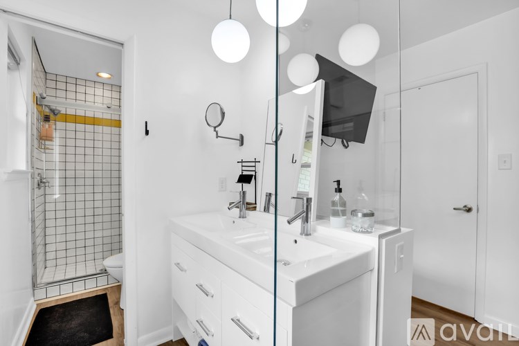 A bathroom with a white sink and a glass shower door.