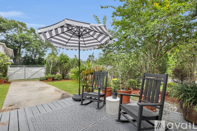 A patio with two chairs and an umbrella.
