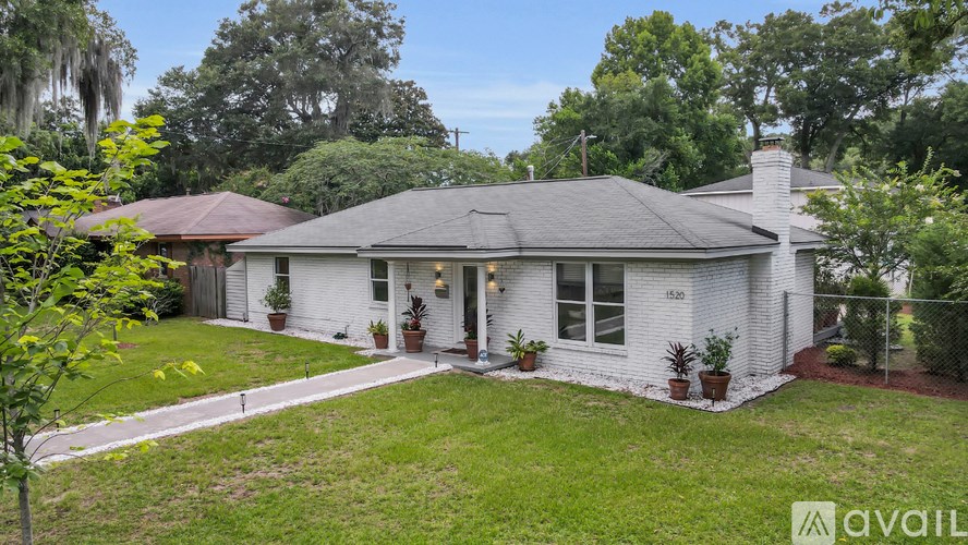 A white house with a brown roof and a small front yard.