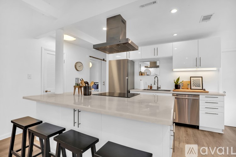 A modern kitchen with a large island and stools.