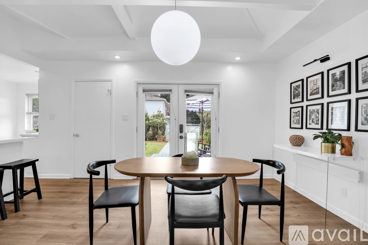 A modern dining room with a round table and chairs.