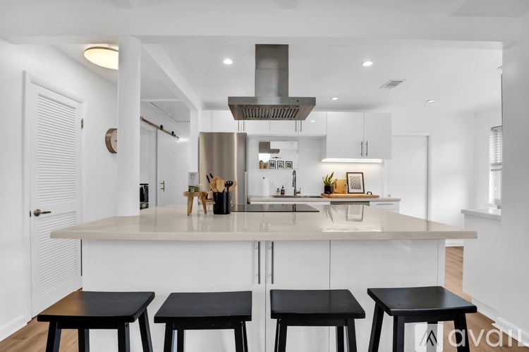 A modern kitchen with a large island and bar stools.