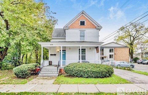 A two-story house with a blue door and white trim.